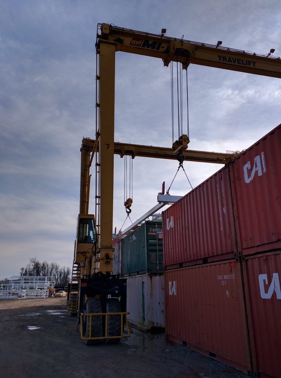 Rubber-tired gantry crane straddling a stack of shipping containers in an intermodal yard